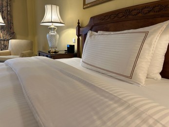 Comfortable large bed with luxury bedding in hotel room