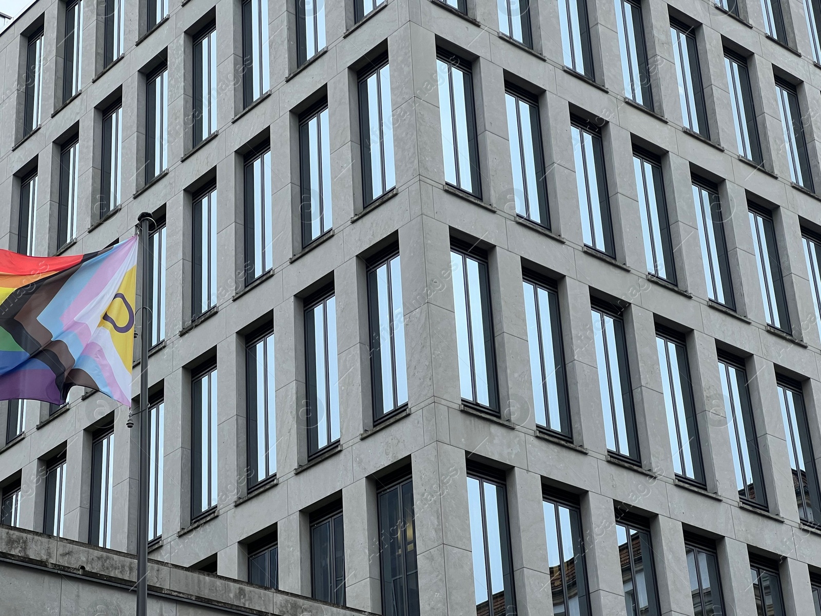 Photo of Berlin, Germany - July 2, 2024: Building with flag of bright progress flag outdoors. LGBT pride