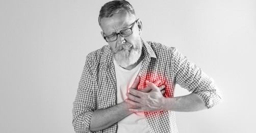 Image of Heart attack. Senior man suffering from severe pain and pressing hands to chest on light background. Banner design