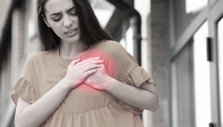 Heart attack. Young woman suffering from pain in chest outdoors. Banner design