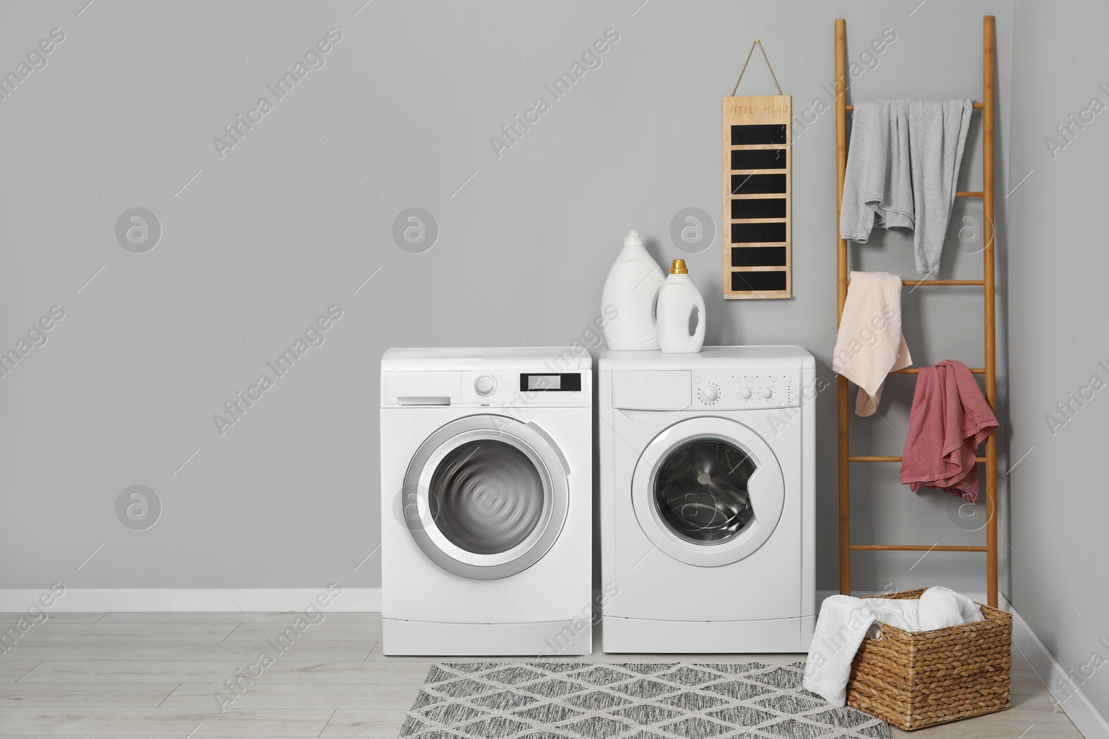 Image of Two washing machines near grey wall in laundry room