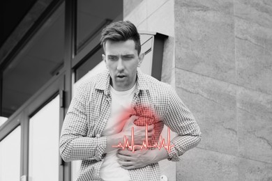 Image of Heart attack. Man suffering from pain in chest outdoors