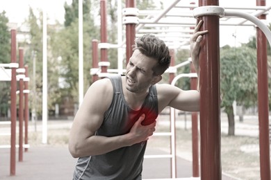 Image of Heart attack. Man suffering from pain in chest at outdoor gym