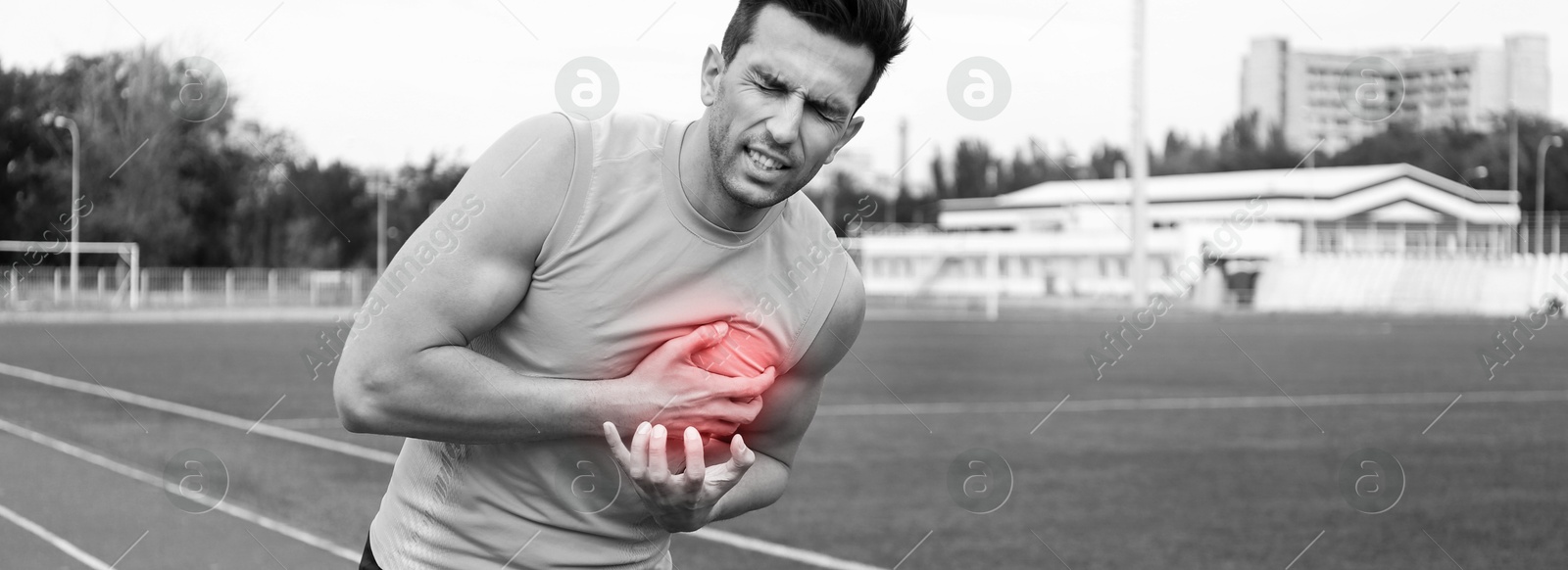 Image of Heart attack. Man writhing in pain and pressing hand to chest at sports ground. Banner design