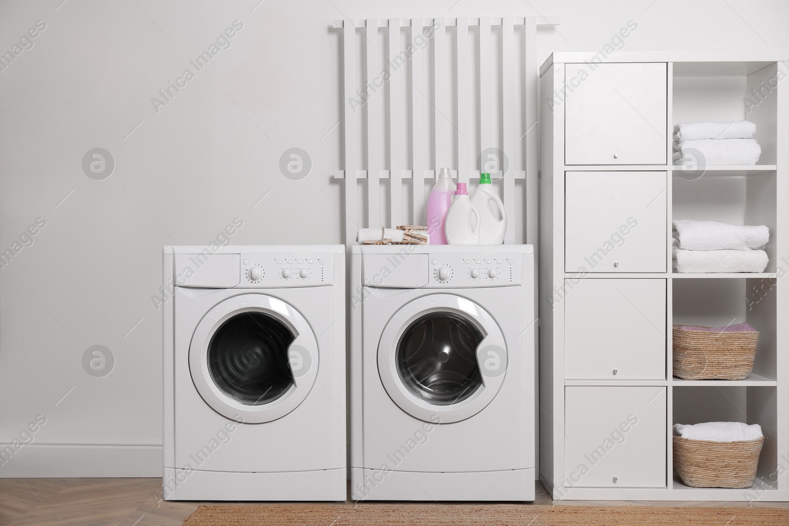 Image of Two washing machines near white wall in laundry room