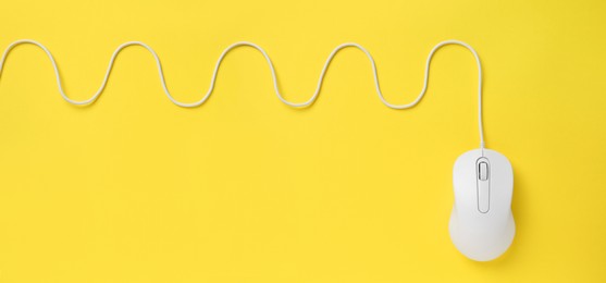 Computer mouse on yellow background, top view. Banner design with space for text