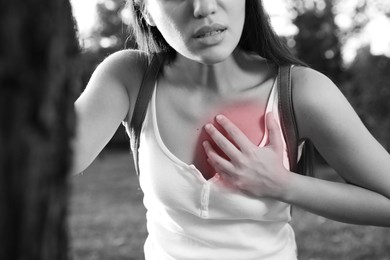 Heart attack. Young woman suffering from pain in chest outdoors, closeup