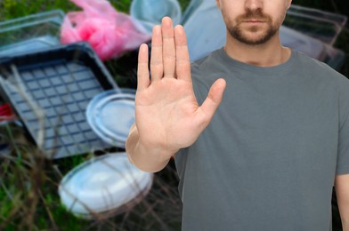 Image of Environmental pollution. Man showing stop gesture, closeup. Garbage on background