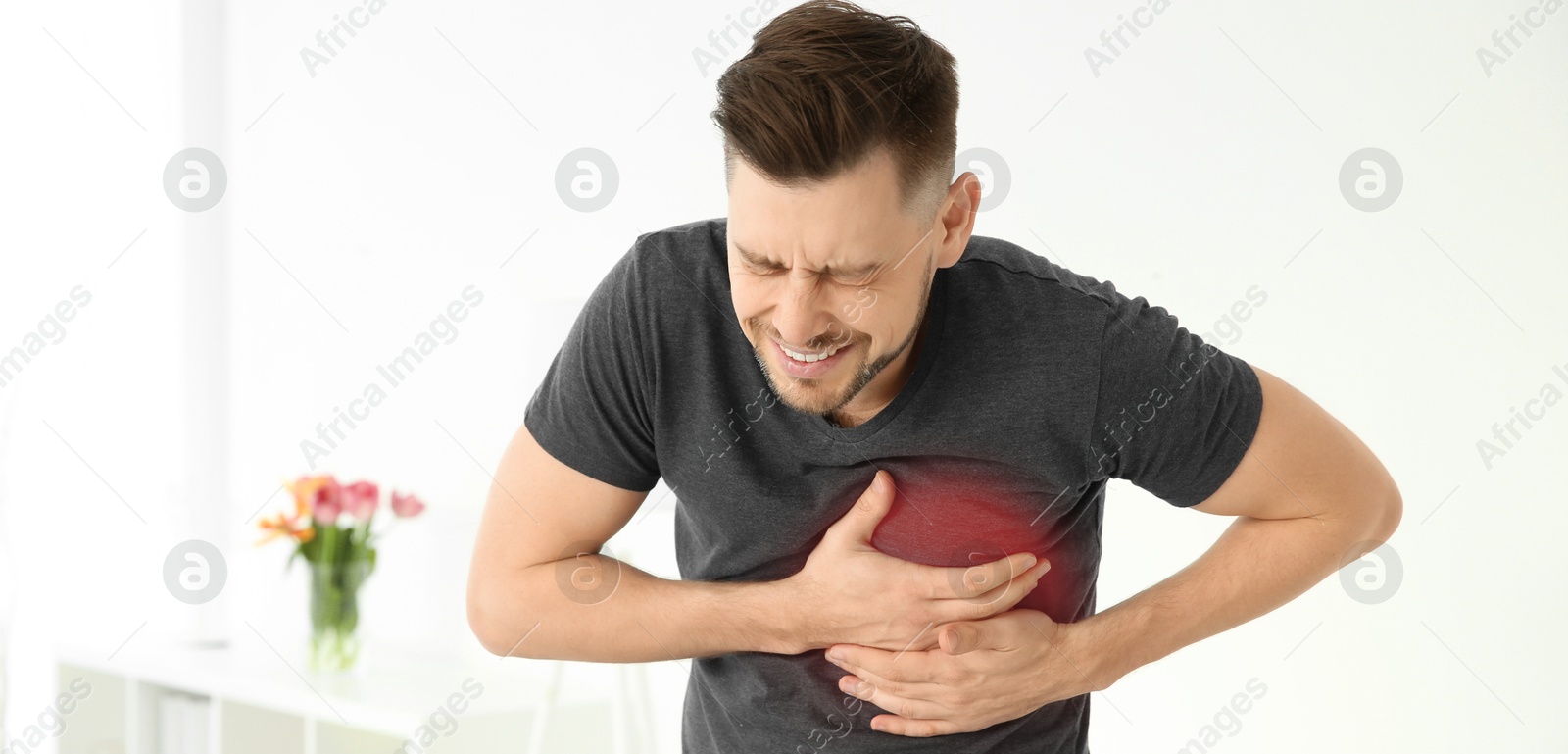 Image of Heart attack. Man writhing in pain and pressing hands to chest on grey background. Banner design