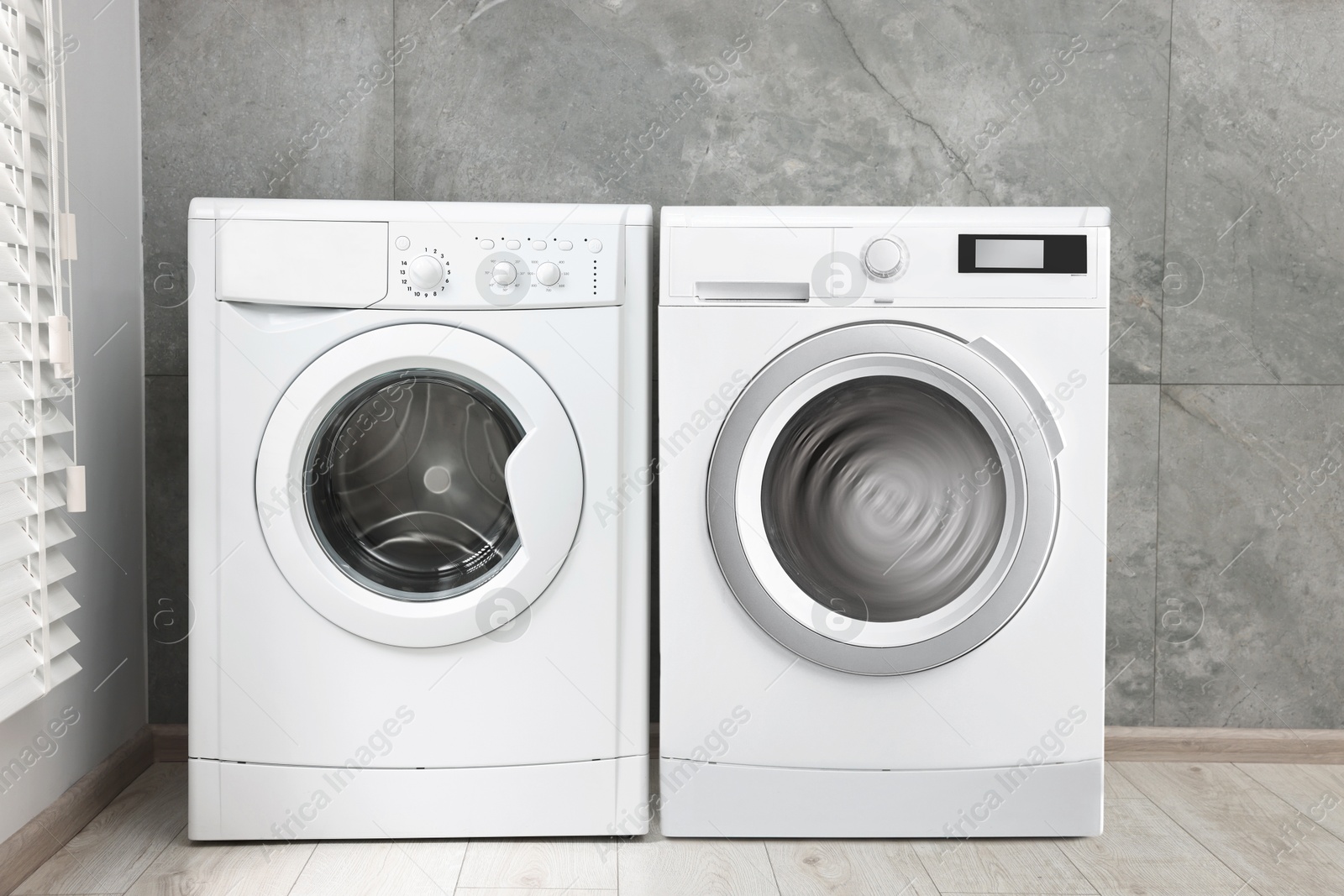 Image of Two washing machines near tiled wall in laundry room