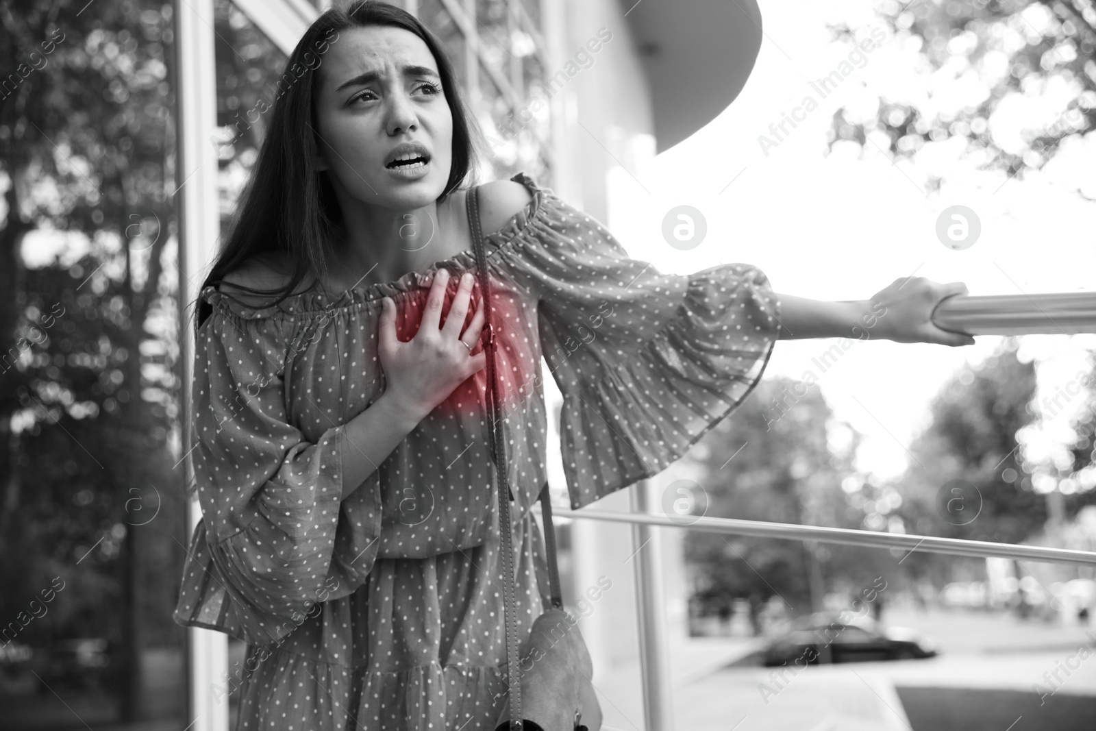 Image of Heart attack. Young woman suffering from pain and pressing hand to chest outdoors