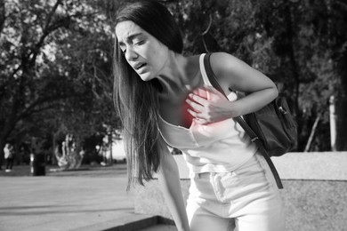 Image of Heart attack. Young woman suffering from pain in chest outdoors