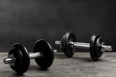 Photo of Two barbells on grey textured table, closeup