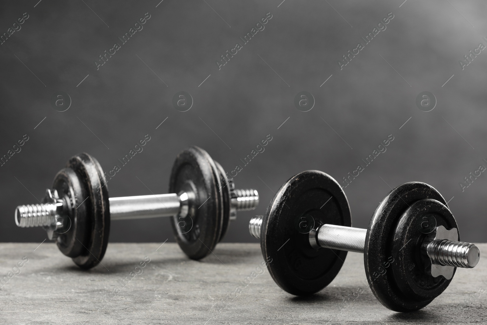 Photo of Two barbells on grey textured table, closeup