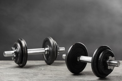 Photo of Two barbells on grey textured table, closeup