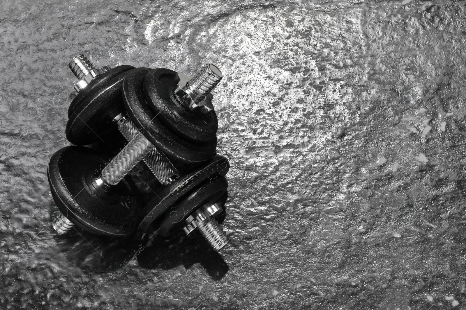 Photo of Barbells on dark textured floor, top view. Space for text