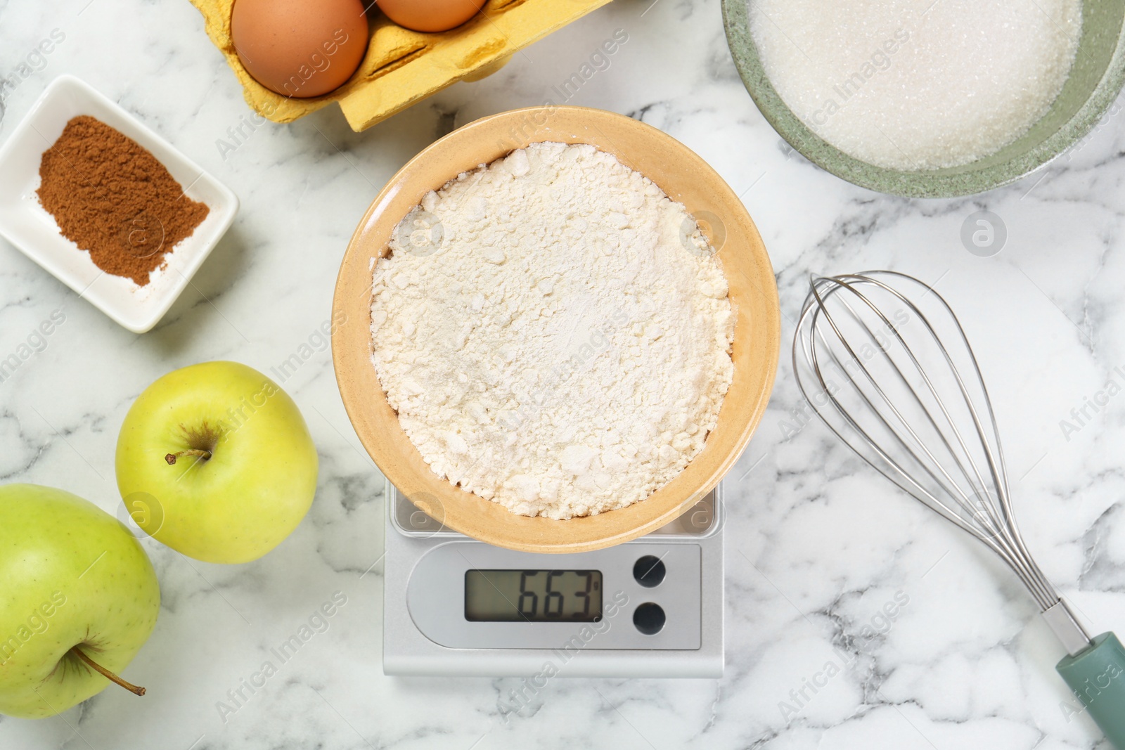 Photo of Flat lay composition of kitchen scale with bowl of flour and products on white marble table