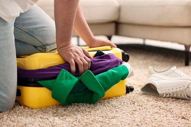 Man packing suitcase on floor at home, closeup