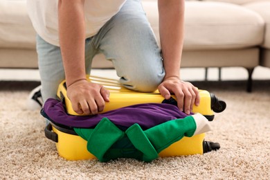 Man packing suitcase on floor at home, closeup