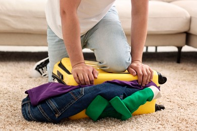 Man packing suitcase on floor at home, closeup