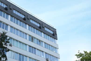 Photo of Modern building with big windows outdoors, low angle view. Space for text