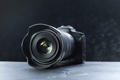 Photo of Modern photo camera on grey table. Photographer's equipment