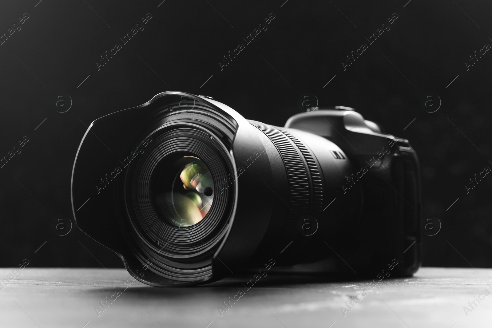 Photo of Modern photo camera on grey table. Photographer's equipment