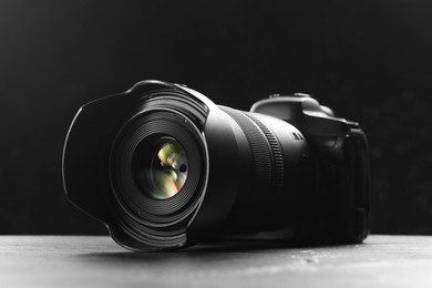 Photo of Modern photo camera on grey table. Photographer's equipment