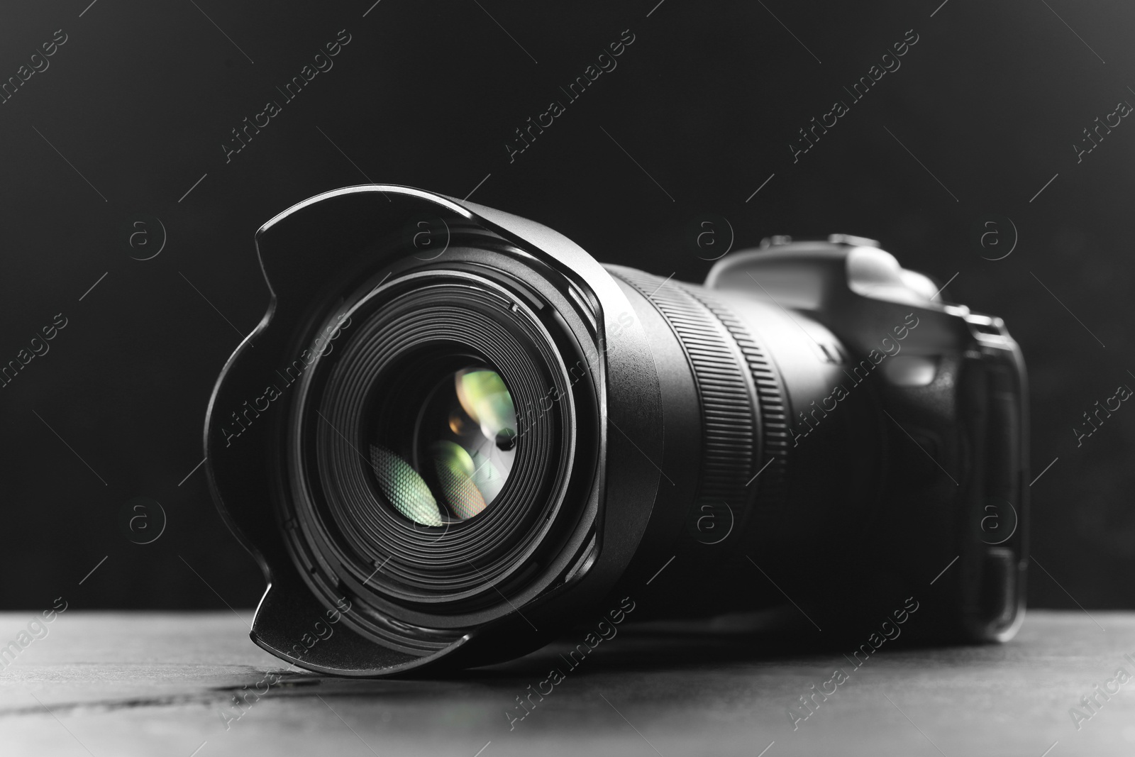 Photo of Modern photo camera on grey table, closeup. Photographer's equipment