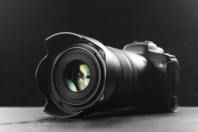 Modern photo camera on grey table, closeup. Photographer's equipment