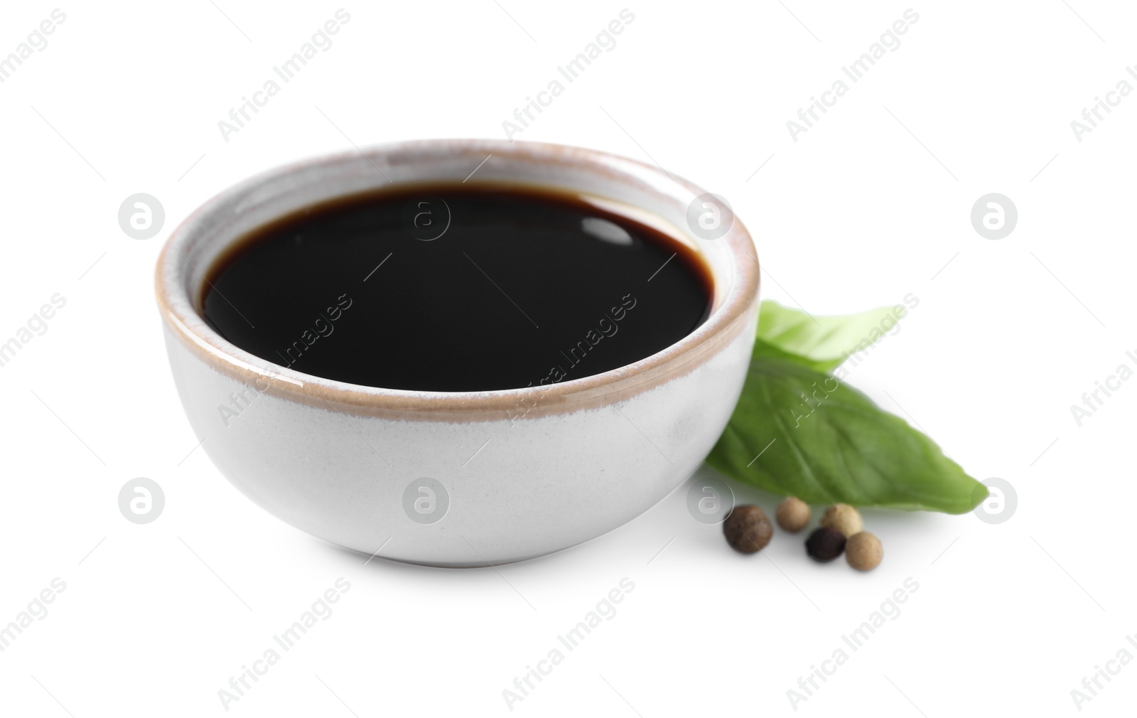 Photo of Delicious balsamic vinegar, basil and peppercorns isolated on white