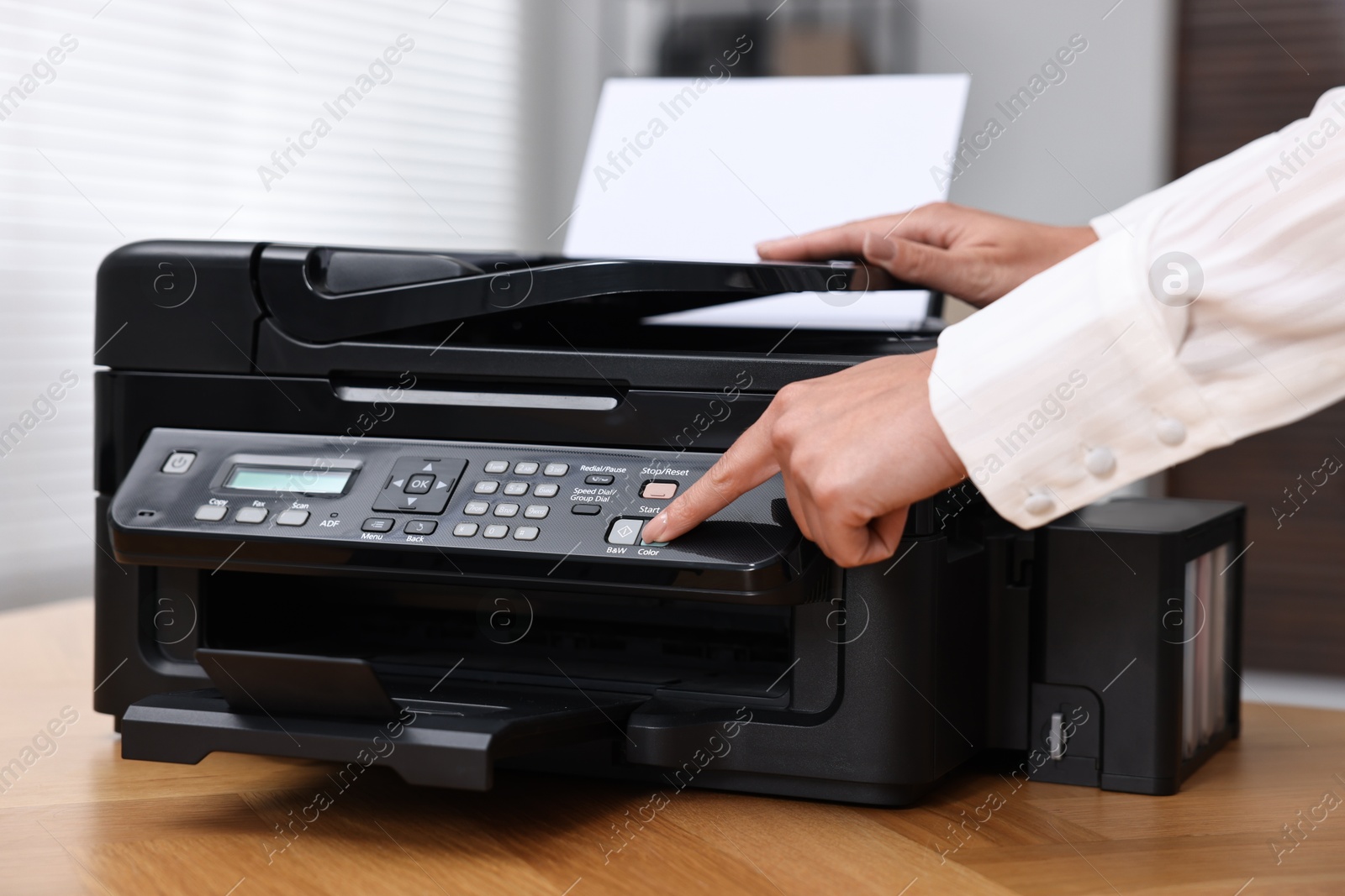 Photo of Woman using modern printer at workplace indoors, closeup