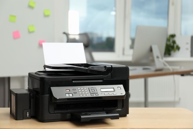 Photo of Modern printer with paper on wooden table in office