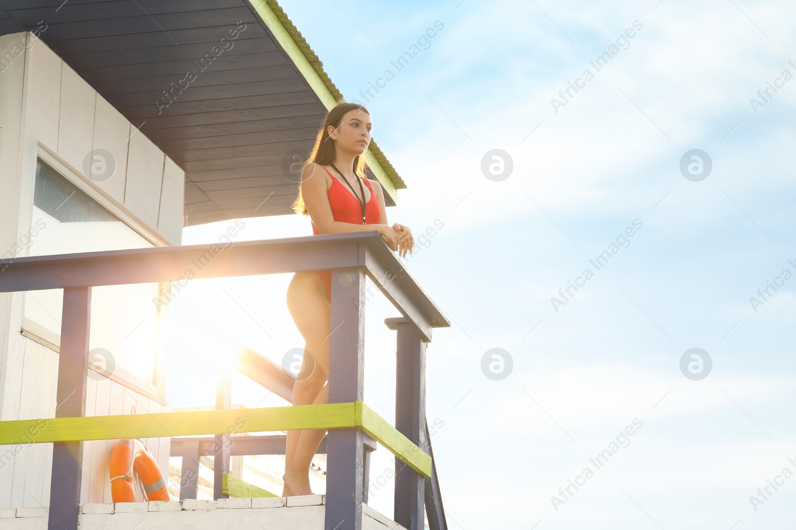 Photo of Beautiful young lifeguard on watch tower against sky