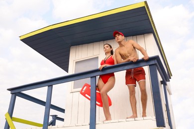 Photo of Professional lifeguards with life buoy and whistles on watch tower