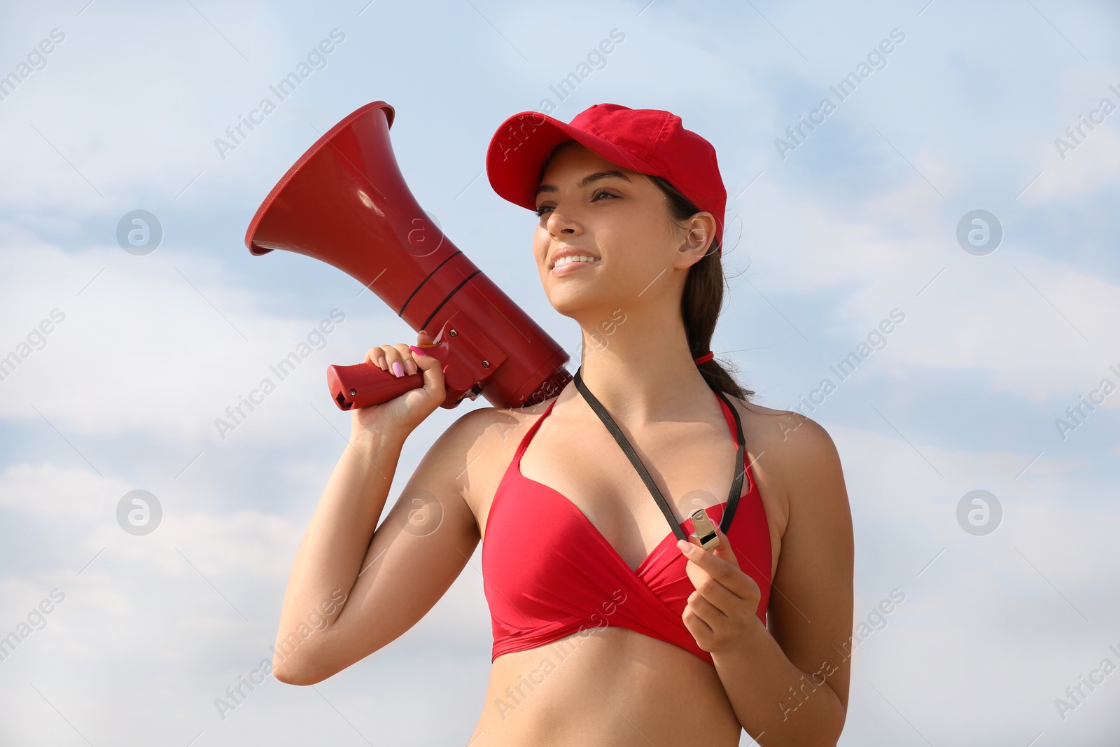 Photo of Beautiful young lifeguard with megaphone against blue sky