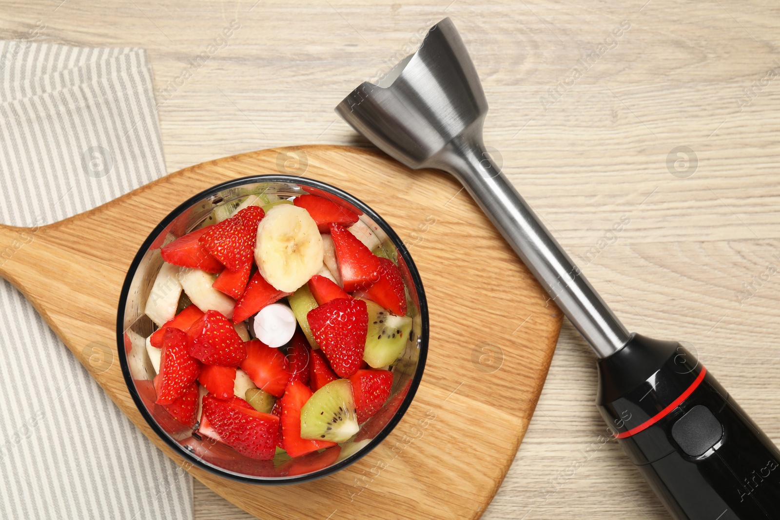 Photo of Hand blender kit with fresh fruits and strawberries on wooden table, flat lay