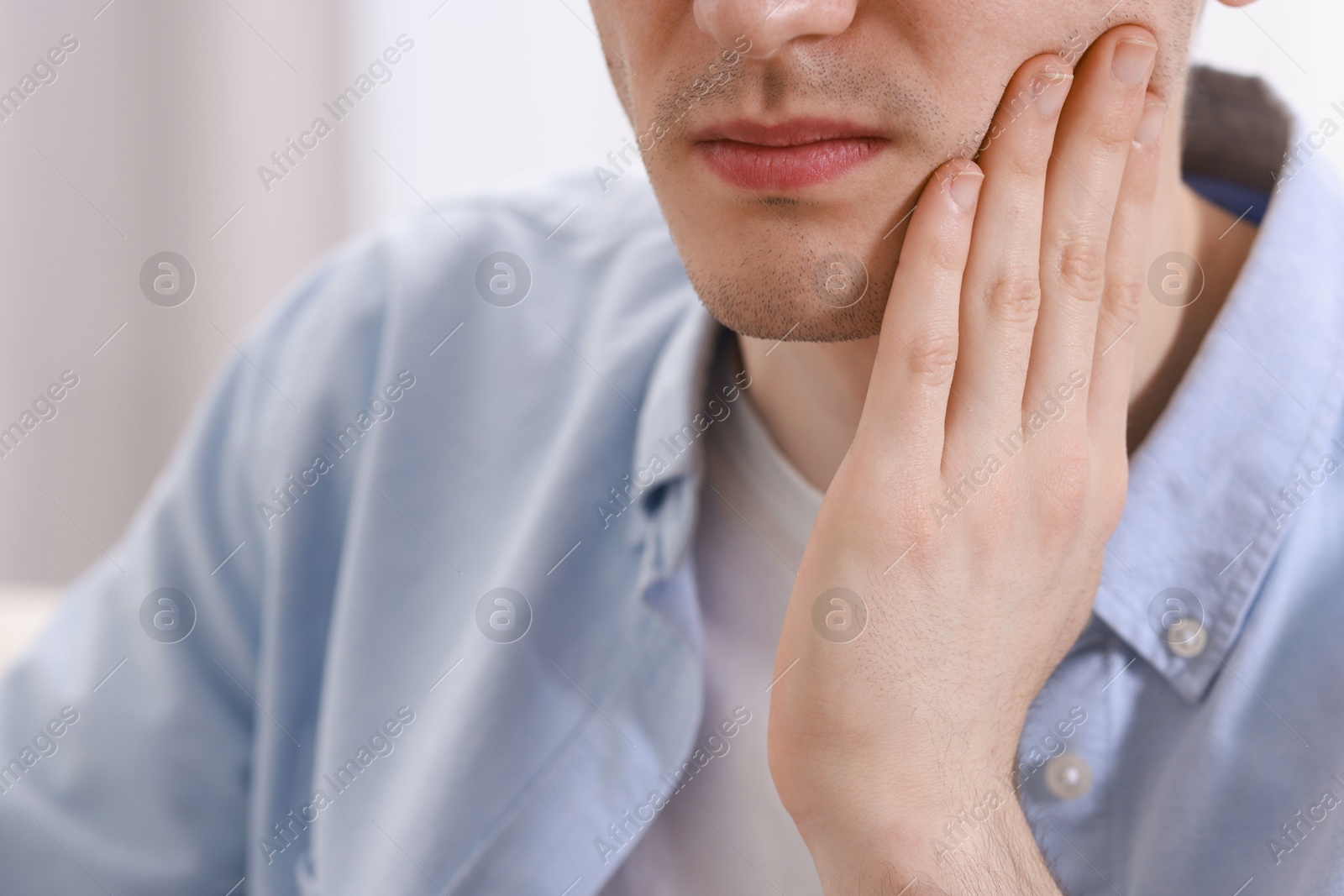 Photo of Man suffering from toothache at home, closeup