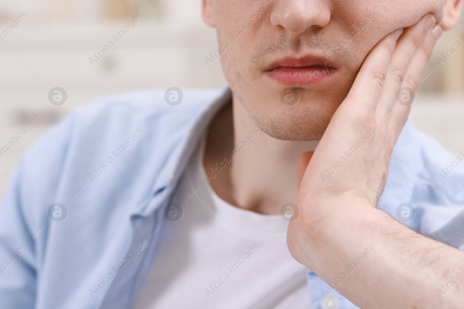 Photo of Man suffering from toothache at home, closeup