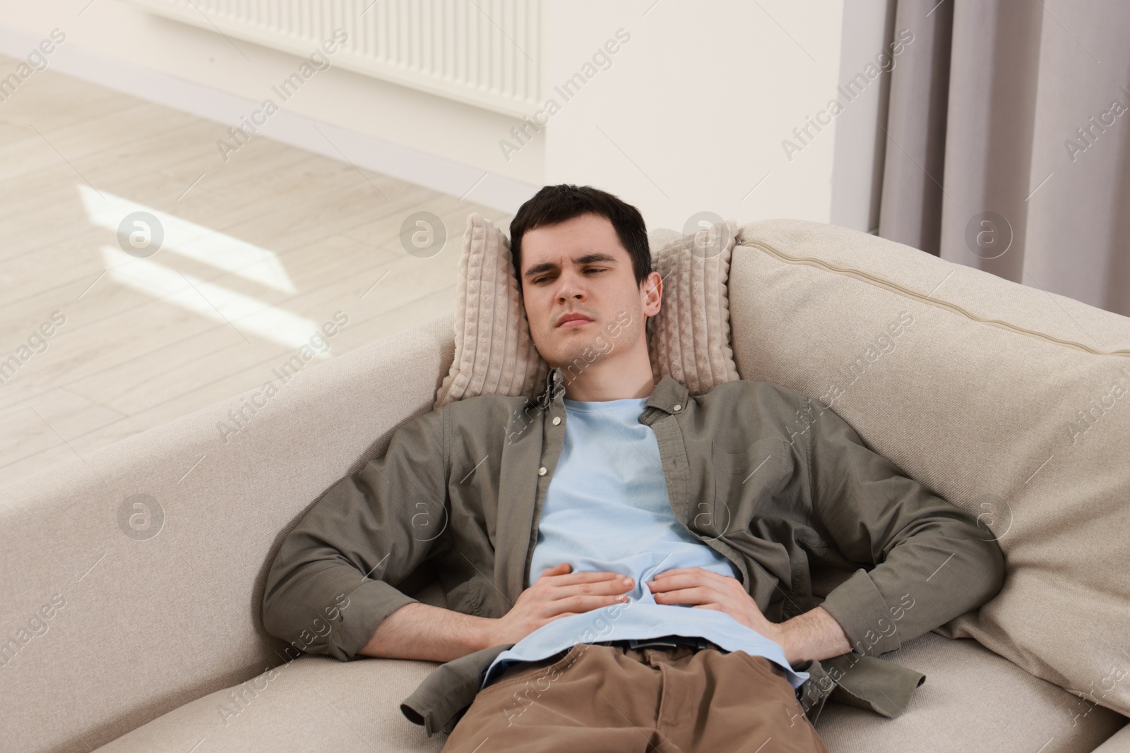 Photo of Man suffering from abdominal pain at home