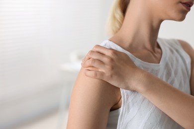 Photo of Sports injury. Woman with pain in shoulder in hospital, closeup