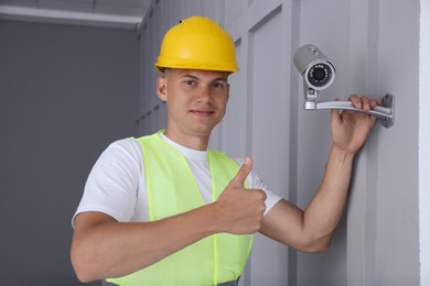 Technician showing thumb up near CCTV camera