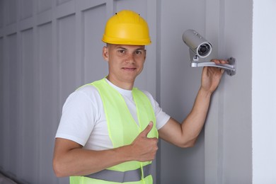 Technician showing thumb up near CCTV camera