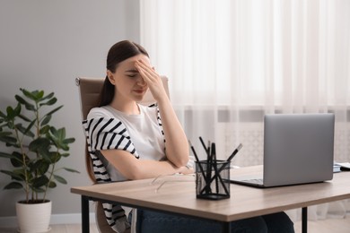 Photo of Embarrassed woman at wooden table with laptop in office