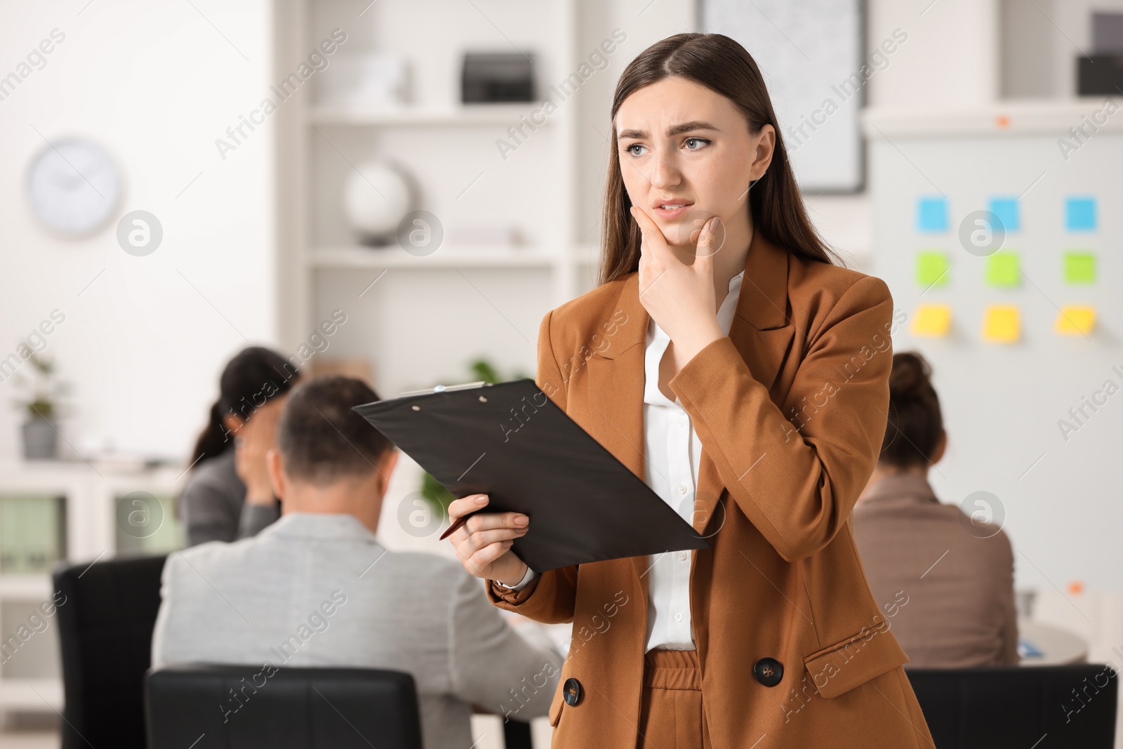 Photo of Woman with clipboard feeling embarrassed during business meeting in office