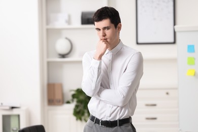 Photo of Portrait of embarrassed young man in office