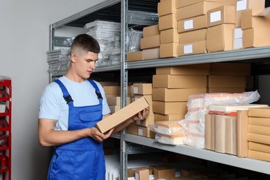 Photo of Young man with many cardboard boxes in auto store