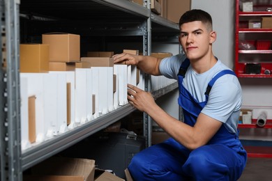 Young man with many cardboard boxes in auto store