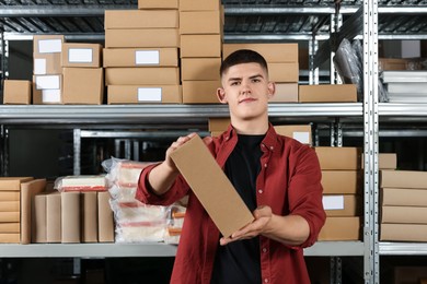 Photo of Young man with cardboard boxes in auto store