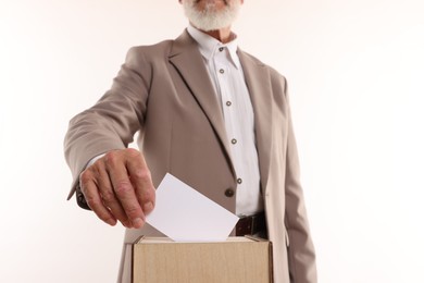 Photo of Referendum. Man putting his vote into ballot box against white background, closeup